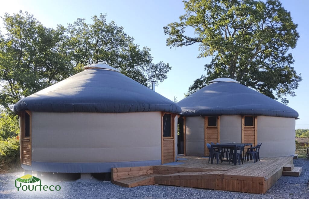 Deux yourtes contemporaines Yourteco reliées autour d’une terrasse en bois