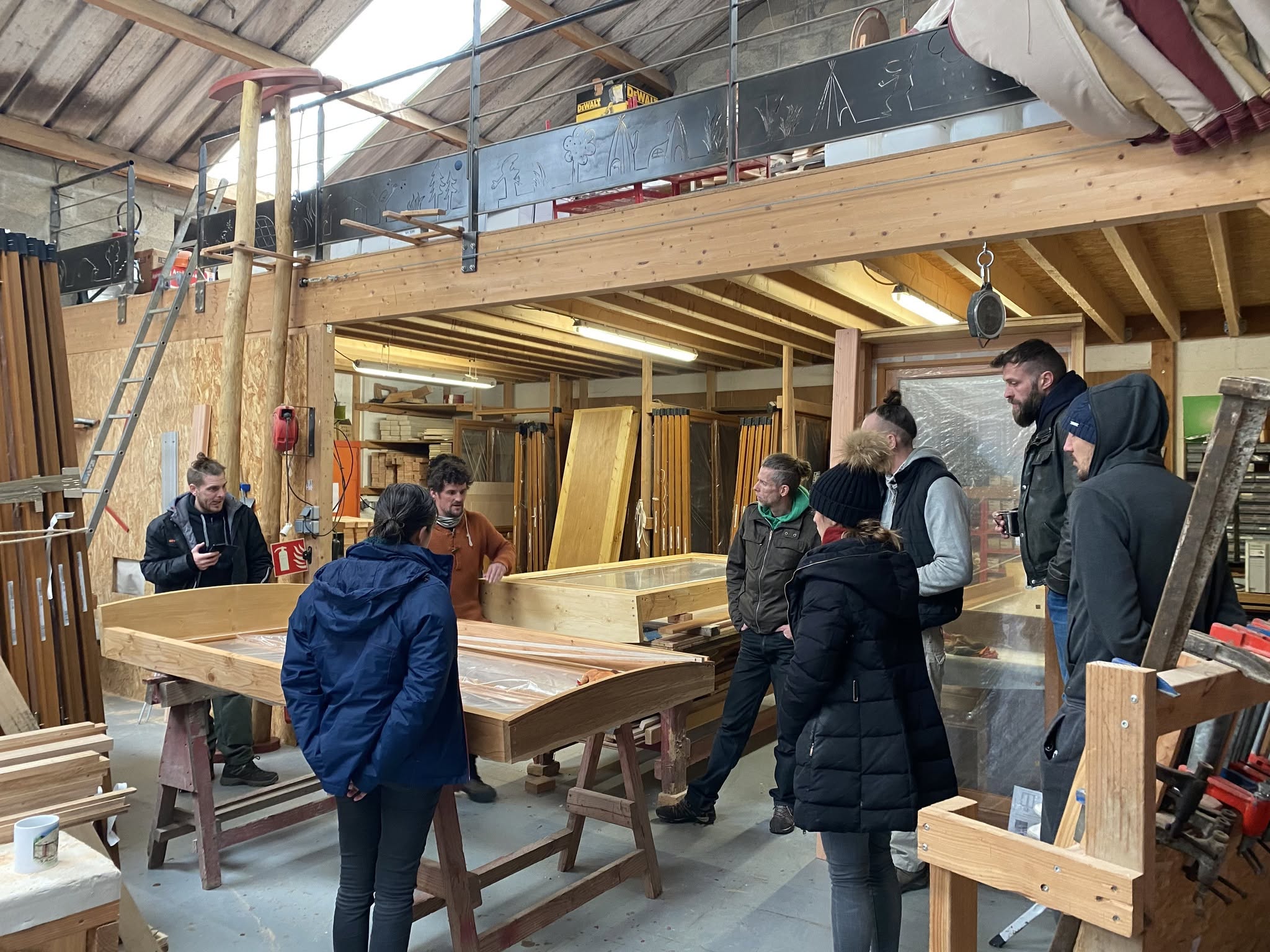 Groupe réuni en atelier autour des éléments en bois d’une yourte