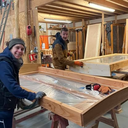 Deux participants travaillent ensemble sur des éléments en bois en atelier